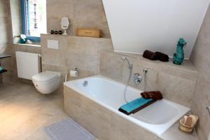 a bathroom with a bath tub and a toilet at Haus Ostseeidyll, App 01 in Neuhaus