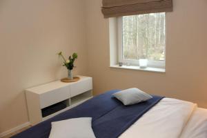 a bedroom with a bed and a window at Strandvilla Birkenallee Haus Sommerlicht in Neuhaus