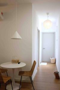 een witte kamer met een tafel en stoelen en een hal bij Stylish 2BR Apartment at Neu Suites, Kuala Lumpur in Kuala Lumpur