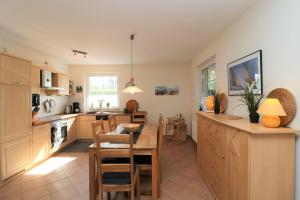 une cuisine avec une table et une salle à manger dans l'établissement Mühlenweg, App 01, à Wieck
