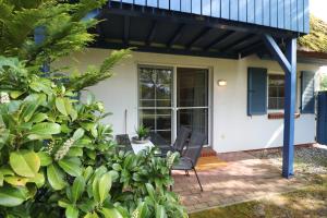 une maison avec 2 chaises sur une terrasse dans l'établissement Mühlenweg, App 01, à Wieck