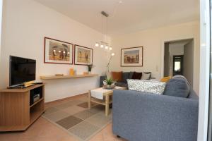 un salon avec un canapé bleu et une télévision dans l'établissement Mühlenweg, App 01, à Wieck