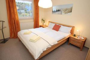 une chambre avec un grand lit avec deux serviettes dessus dans l'établissement Mühlenweg, App 01, à Wieck