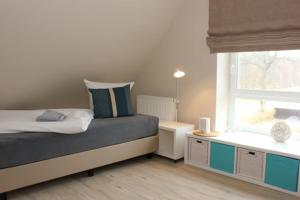 Un dormitorio pequeño con una cama y una ventana. en Strandvilla Birkenallee Haus Meerzeit, en Neuhaus 25 fotos más