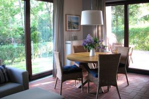 Ferienhäuser Ferienhaus Xenia في ويك: غرفة معيشة مع طاولة طعام وكراسي