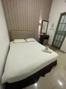 uma grande cama branca num quarto com um espelho em One Point Hotel @ Airport (Kuching) em Kuching