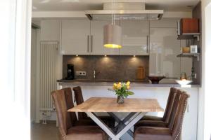 a kitchen with a table with chairs and a vase of flowers at Ferienhäuser Reethaus am Deich in Dierhagen