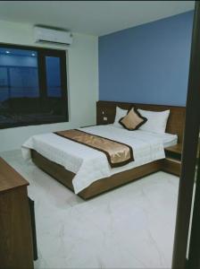 um quarto com uma cama grande e uma janela grande em Bảo An hotel Đảo Quan Lạn em Làng Liễu