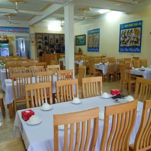 uma sala de jantar com mesas e cadeiras com toalha de mesa branca em Bảo An hotel Đảo Quan Lạn em Làng Liễu