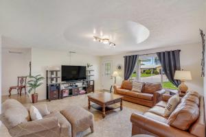 a living room with couches and a flat screen tv at Fun In The Sun: Canal Access in Cape Coral