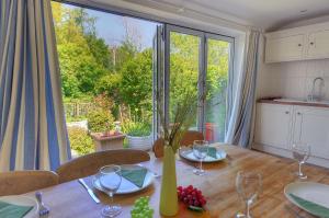 a dining room with a table and a large window at 24 Mill Green in Lyme Regis