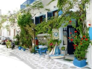 a white building with a blue door and some plants at Hotel Elizabeth in Naxos Chora