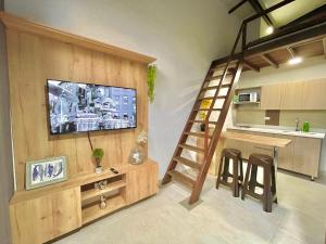 eine Küche mit einem Wohnzimmer mit einer Leiter und einem TV in der Unterkunft APARTAMENTOS EN LAURELES, MEDELLÍN in Medellín