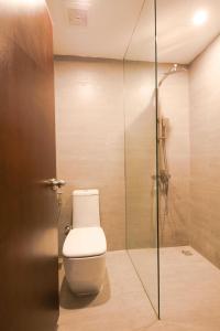 uma casa de banho com um WC e uma cabina de duche em vidro. em H&A Homestay - 40m, New Built, Center Location, Quiet Place, Full Facilities em Hanói