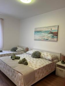 two beds in a room with a painting on the wall at Apartment Ivica in Sućuraj