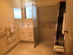 a small bathroom with a shower and a sink at RELAX on Ronald Street in Devonport