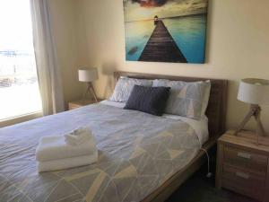 ein Schlafzimmer mit einem Bett mit einem Bild an der Wand in der Unterkunft RELAX on Ronald Street in Devonport