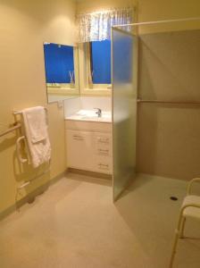 a small bathroom with a sink and a refrigerator at RELAX on Ronald Street in Devonport