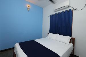 um quarto azul com uma cama com uma cortina azul em Omkara - The Fives Guest house em Tiruvannamalai