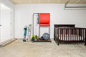 um quarto com um berço e uma cadeira vermelha em Cozy Smart Home with Pool & Gym em Fort Worth