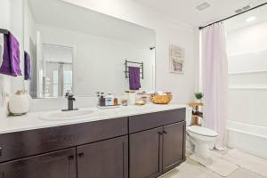 uma casa de banho com um lavatório e um WC em Cozy Smart Home with Pool & Gym em Fort Worth