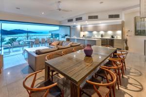 a kitchen and living room with a table and a couch at North Cape 5 on Hamilton Island by HIHA in Hamilton Island
