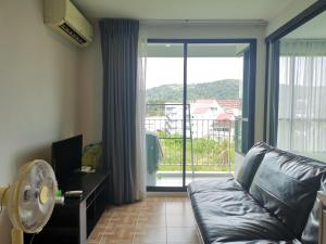 a living room with a couch and a large window at 5 Floor - Centrio Condominium in Phuket Town - 30 mins to beaches in Phuket