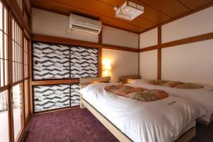 Postel nebo postele na pokoji v ubytování Tsukasaya Ryokan