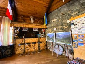 um bar com bancos numa sala com uma parede de pedra em Mountain Base ARTUCH em Panjakent