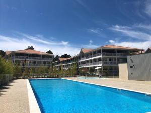 a swimming pool in front of a building at Ville les flots bleus Proche golf Arcachon in La Teste-de-Buch