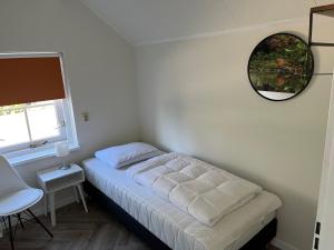 a small bedroom with a bed and a mirror at Villa Victoria with sauna in Ermelo in Ermelo