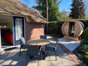a table and chairs in front of a house at Villa Victoria with sauna in Ermelo in Ermelo