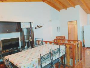 uma sala de estar com uma mesa e uma televisão e uma mesa e um tvicter em Cabaña El Mirador em Ushuaia