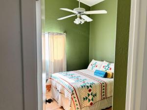 a bedroom with a bed and a ceiling fan at Rustic retreat room with desk in country house in Hemet