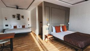 um quarto de hotel com duas camas e uma secretária em Bendheka - Cliff Front Cottages Coorg em Gonikoppal