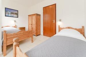 una camera con due letti e una porta in legno di Felmare a Timmendorfer Strand