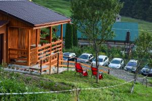 une cabane en bois avec deux chaises rouges devant elle dans l'établissement Cabana Anna Colibita, à Colibiţa