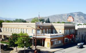 a large building on a street with a mountain in the background at Irma Hotel in Cody