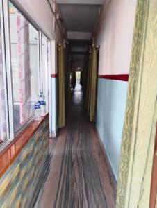 a corridor of a building with a long floor and windows at Bikash Bhawan Lodge in Siliguri