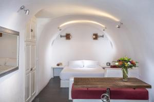 pokój hotelowy z łóżkiem i stołem w obiekcie White Pearl Villas w mieście Oia