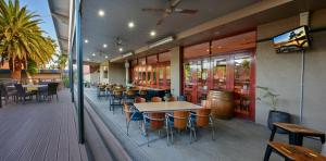 a restaurant with tables and chairs and a bar at Westland Hotel Motel in Whyalla