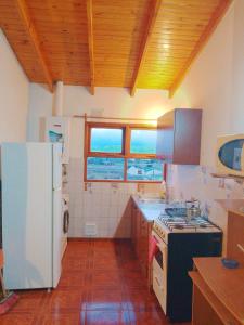a kitchen with a white refrigerator and a stove at Cabaña El Horizonte Patagónico in Ushuaia +7 photos