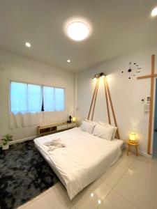Un dormitorio con una gran cama blanca y una ventana en กาลเวลา เกาะสีชัง en Ban Tha Thewawong