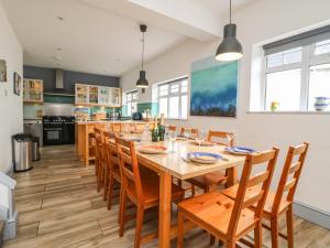 a dining room with a large wooden table and chairs at Little Trelawns in Mawgan Porth