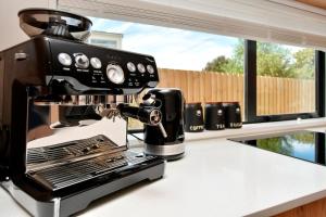 a black and white coffee machine on a counter at Āta Haere - Christchurch Holiday Homes in Christchurch