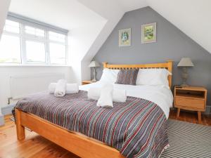 um quarto com uma cama grande e toalhas em Little Trelawns em Mawgan Porth