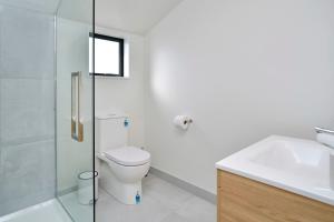 a bathroom with a toilet and a sink and a shower at Āta Haere - Christchurch Holiday Homes in Christchurch