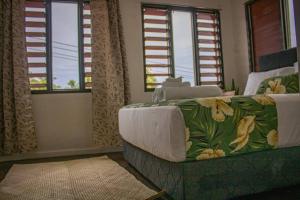 a living room with a couch and windows at Yaubula Accommodation in Nadi