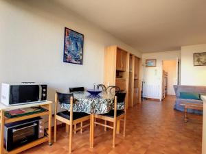 salon ze stołem z krzesłami i telewizorem w obiekcie Studio cabine sur plage avec parking et animaux admis - FR-1-715-63 w mieście Palavas-les-Flots
