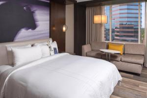 um quarto de hotel com uma cama, um sofá e uma janela em Durham Marriott City Center em Durham